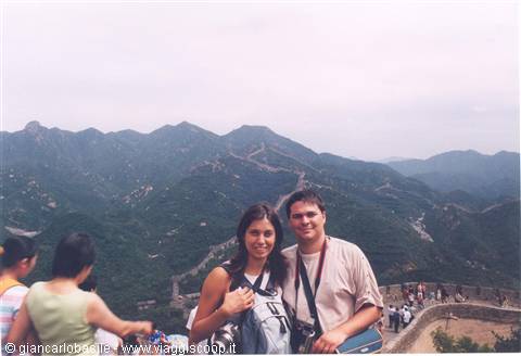 Tourists with camera on the Great Wall among green mountains