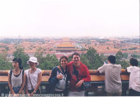 Tourists posing before the golden rooftops of the Forbidden City, Beijing
