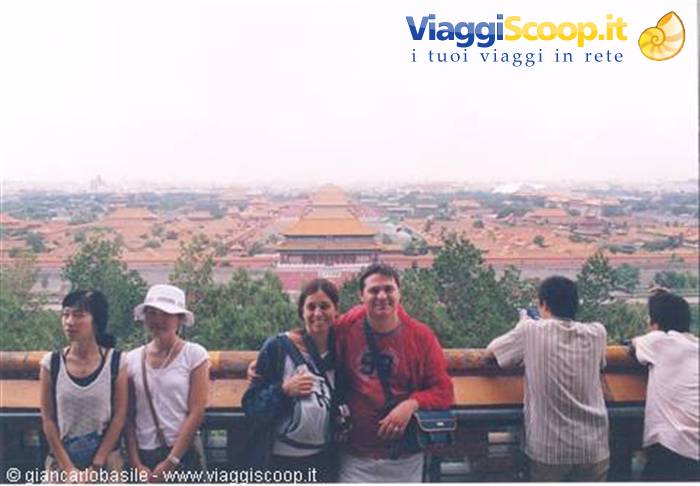 Tourists posing before the golden rooftops of the Forbidden City, Beijing