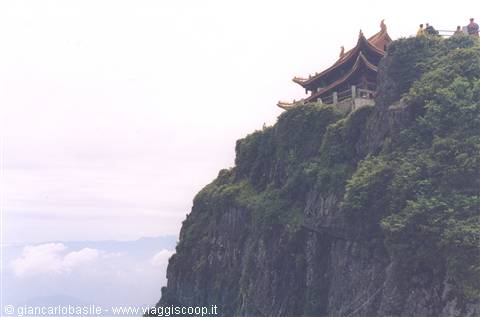 Temple with golden roofs atop the green cliff of Mount Emei