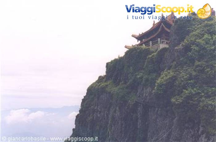 Temple with golden roofs atop the green cliff of Mount Emei