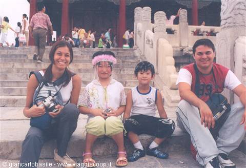 Couple with two children sitting on marble steps of the Forbidden City