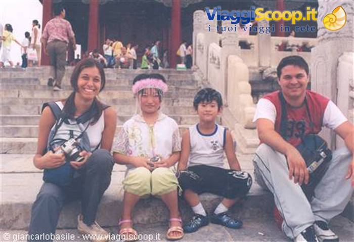Couple with two children sitting on marble steps of the Forbidden City