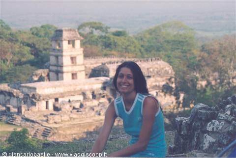 Smiling woman in front of the Mayan temple of Palenque surrounded by jungle