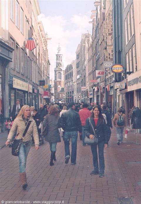 Shoppers walking on a pedestrian street with the Munttoren tower, Amsterdam