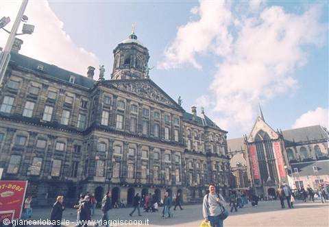 Tourists walk across Dam Square in front of Amsterdam's Royal Palace