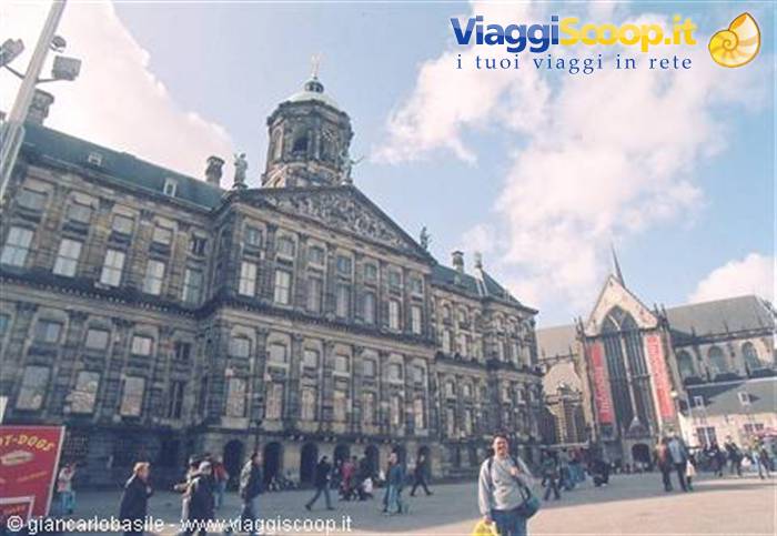 Tourists walk across Dam Square in front of Amsterdam's Royal Palace