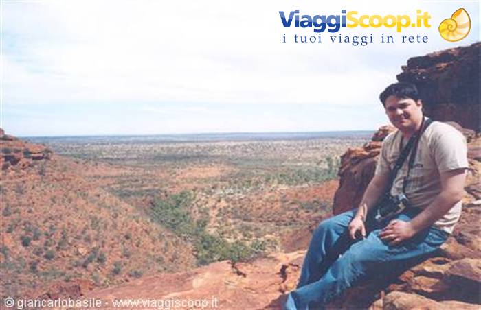 Tourist sitting on the red rock of Kings Canyon, Australia