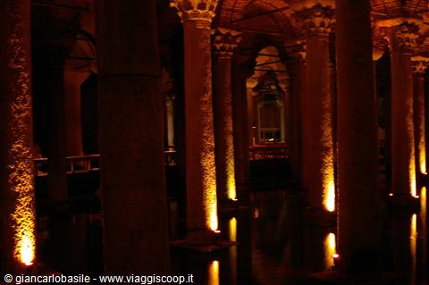 Stone columns lit orange inside the Basilica Cistern in Istanbul