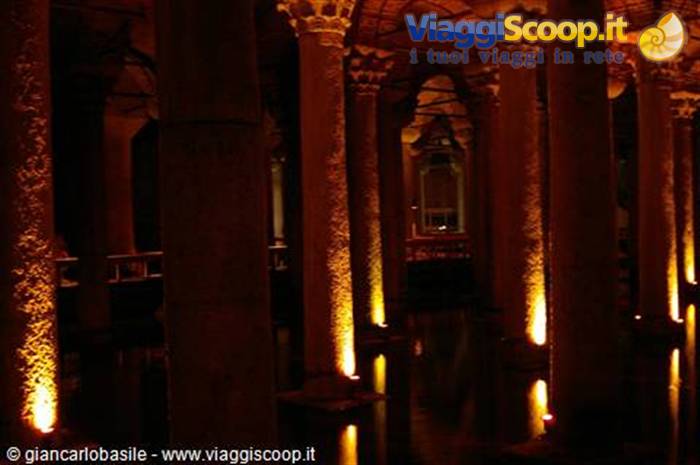 Stone columns lit orange inside the Basilica Cistern in Istanbul