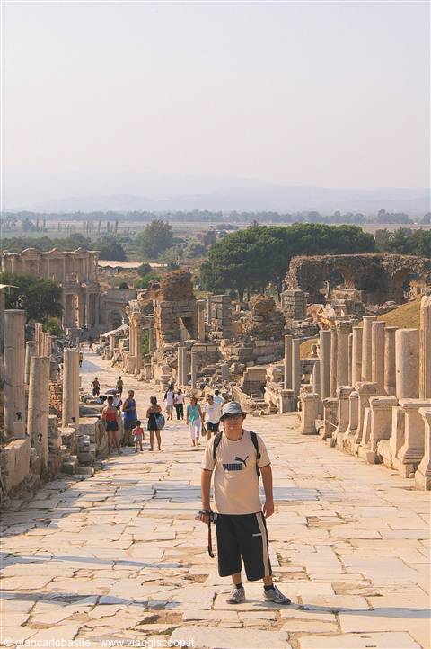 Tourist with camera on the marble road among the ruins of Ephesus