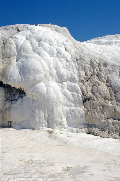 White travertine formations at Pamukkale under a clear blue sky