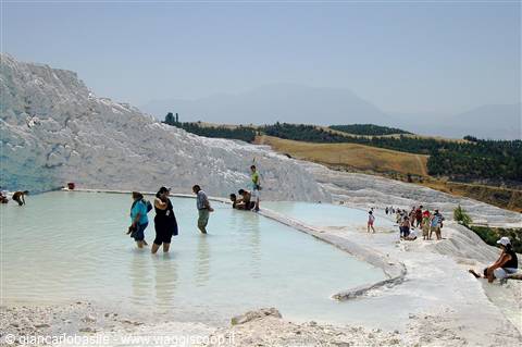 Barefoot tourists wading in the white travertine pools of Pamukkale