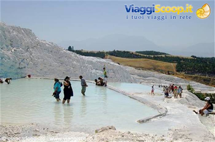 Barefoot tourists wading in the white travertine pools of Pamukkale