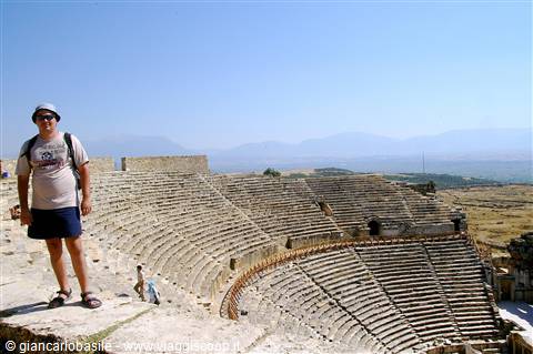 Tourist on the large ancient theater of Hierapolis, stone seats under the sun
