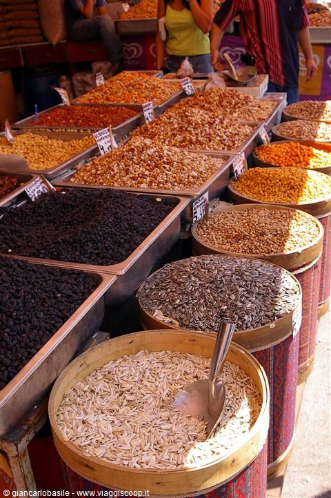 Trays of raisins, nuts and sunflower seeds at a bustling open-air market