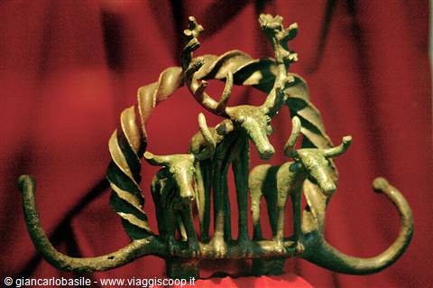 Bronze statuette of a stag with spiral antlers and three oxen, red backdrop