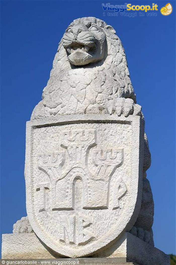 Stone lion statue holding the three-towers coat of arms, San Marino