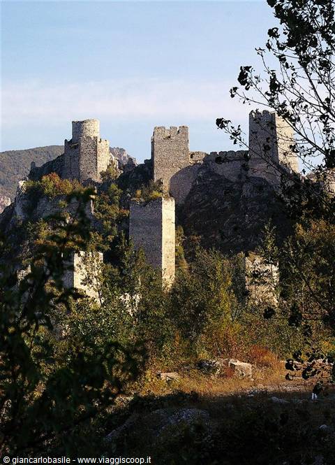 Rocca Calascio, stone castle towers among autumn trees under clear light