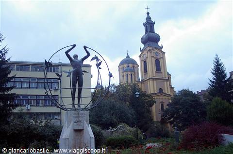 Man statue inside metal globe in front of Sarajevo Orthodox cathedral