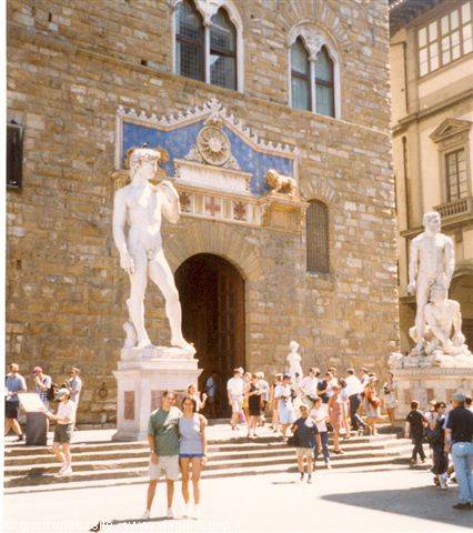 Couple in front of the marble David replica at Palazzo Vecchio entrance