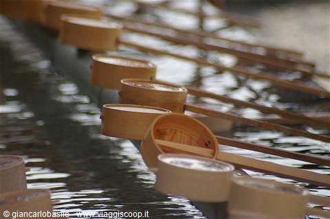  wooden ladles lined up on a shrine water purification basin