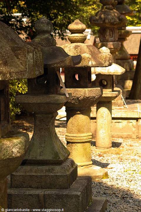 Rows of weathered stone lanterns at Kasuga Taisha shrine, warm light