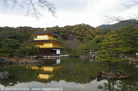 Golden pavilion of Kinkaku-ji in Kyoto reflected in a pond among pines