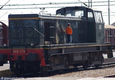 Child in orange sweatshirt standing on the footboard of old diesel locomotive 642-173