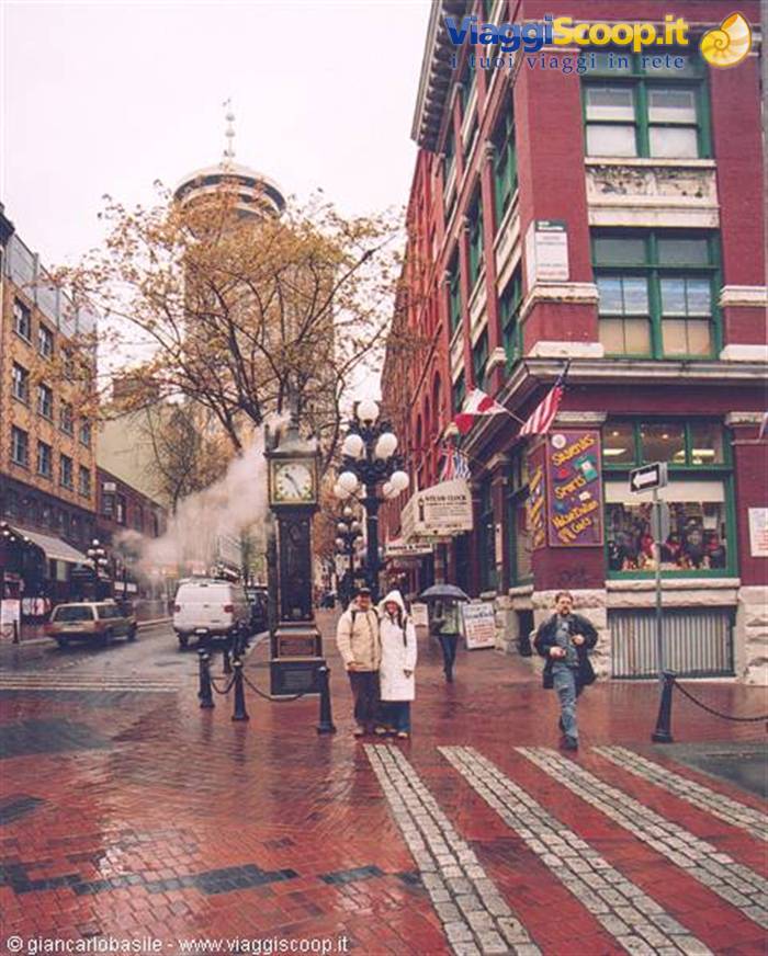 Couple in the rain beside the Gastown steam clock, wet red bricks