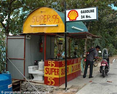 Small Super 95 gasoline stand with Shell sign, man refilling his scooter
