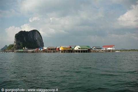Colorful stilt houses in front of Ko Panyi limestone cliff