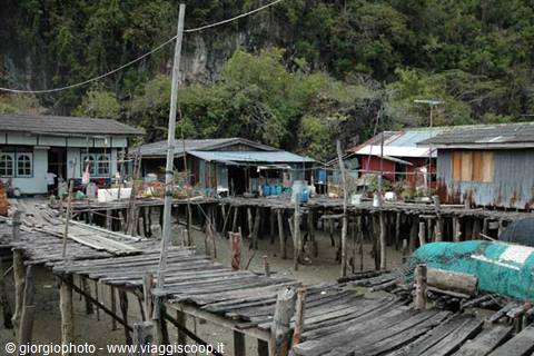 Wooden stilt village, colored houses on low water, green limestone cliffs