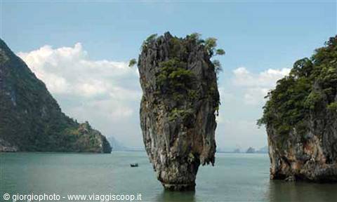 Khao Phing Kan limestone islet in Phang Nga Bay, small boat passing by