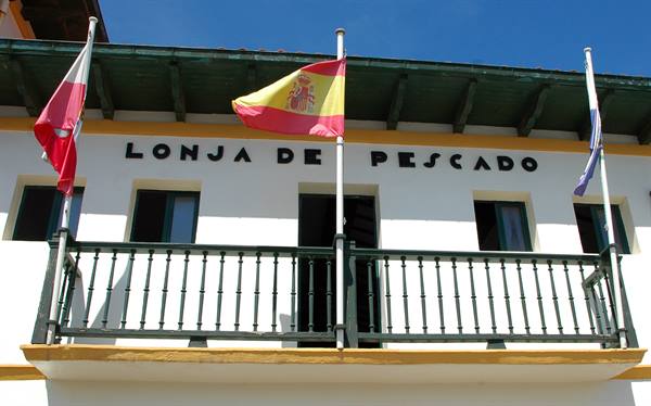 Balcony of the Lonja de Pescado, Spanish flag waving against blue sky