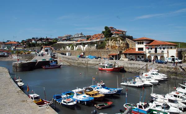 Leisure boats and fishing vessels moored in the harbour beneath red-roofed houses
