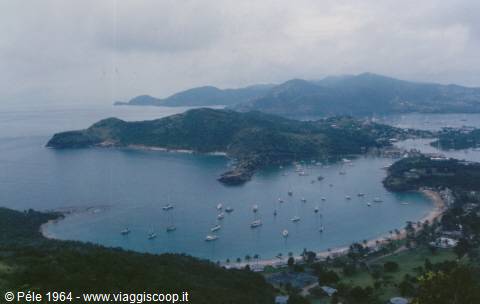 Green bay with many sailboats anchored between the hills