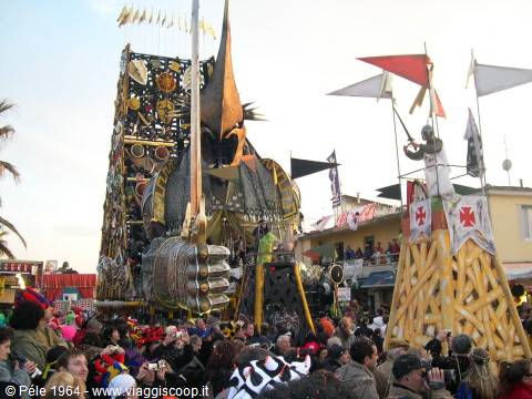 Carnival float with giant warrior surrounded by crowd and palm trees