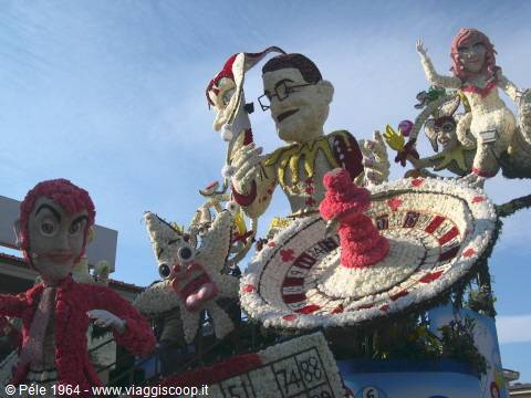 Flower parade float with decorated figures and a roulette wheel, carnival