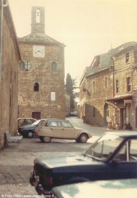 Vintage cars parked on the stone square in front of the clock tower
