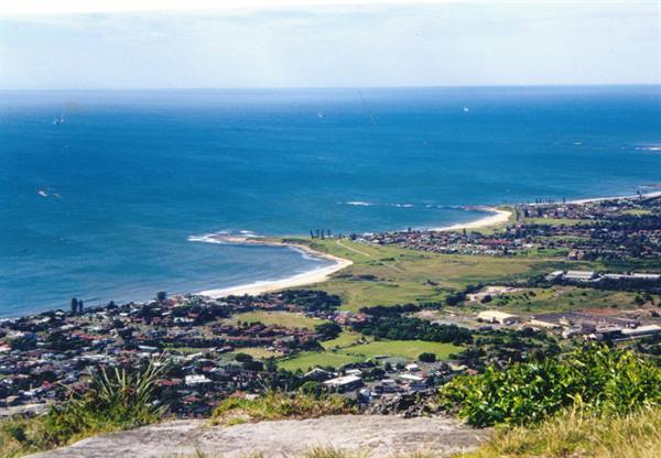 Coastal town with sandy beach and blue ocean seen from above