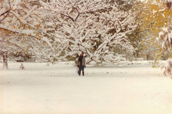 Man walks on snow among snow-covered trees in the park