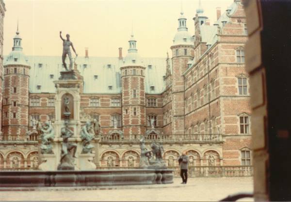 Fountain with statues in Frederiksborg Castle courtyard, red brick towers