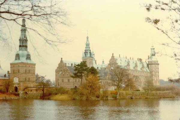 Frederiksborg Castle, red brick with copper-green spires reflected in the lake