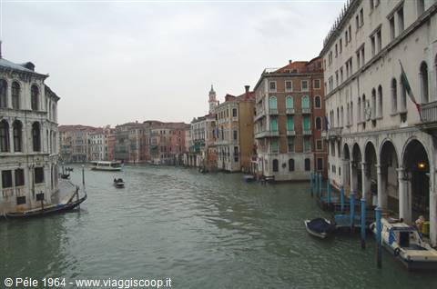 Grand Canal in Venice with boats and old palaces under grey sky