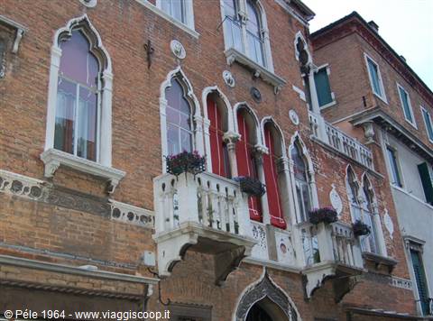Brick Gothic palace with red triple windows and marble balconies in Venice