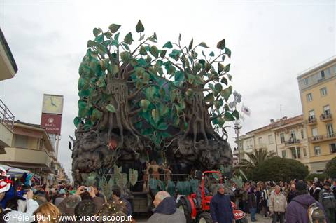 Allegorical float with trees and roots at Viareggio carnival, crowd along the street