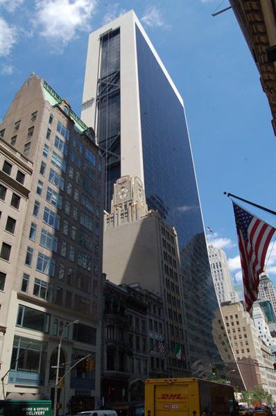 Solow Building tower in New York above old facades, American flag and DHL truck