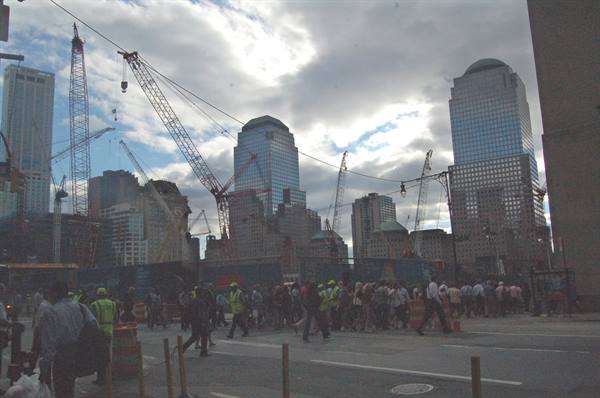 Workers and pedestrians cross a construction site with cranes at Ground Zero