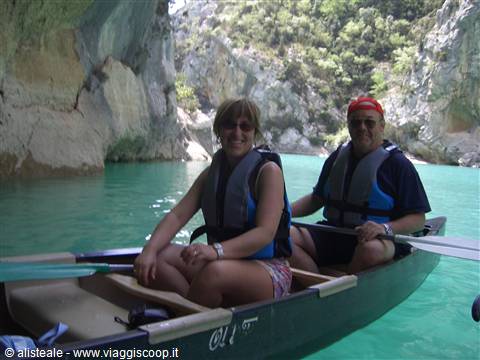 Couple paddling a canoe with life vests on turquoise Verdon Gorge waters